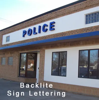 Backlit blue Police letters on a brick storefront