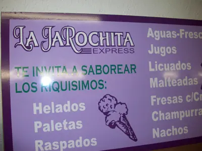 Purple and green bilingual wall sign for La Jarochita Express